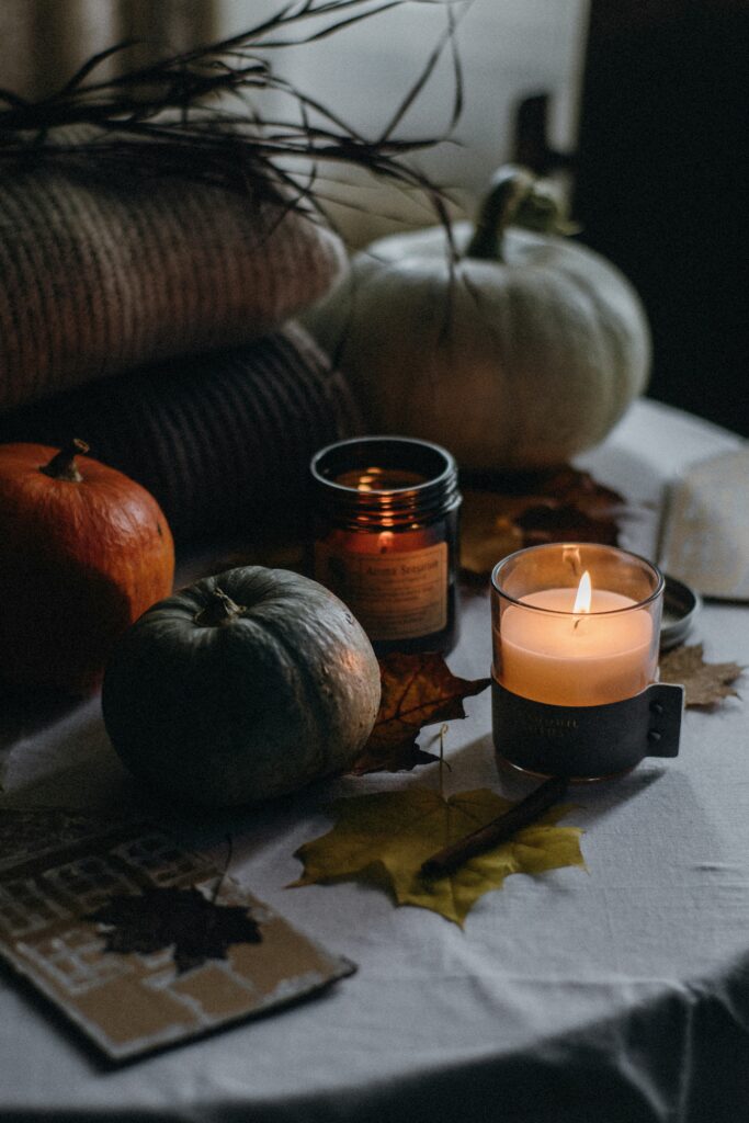An aesthetic scene showing pumpkins beautifully complementing candles in a dark and dreamy atmosphere.