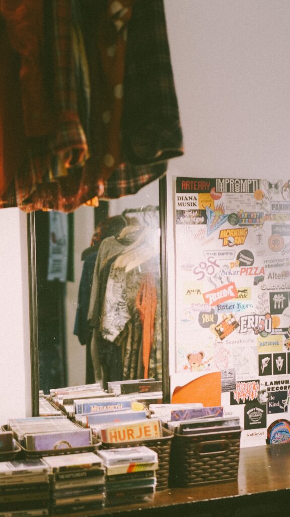Vintage record player , records dresses posters and lighting making a bedroom somewhere in 90s and giving nostalgia 