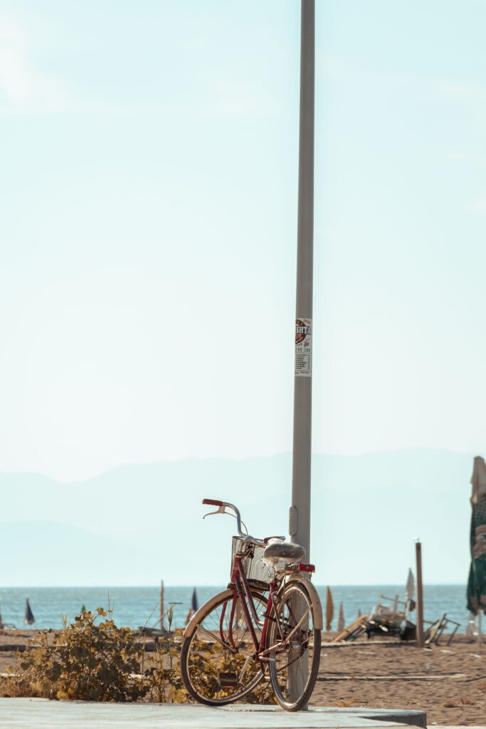 "Vintage bicycle parked near a beach on a bright summer day, representing carefree childhood adventures and simple living."