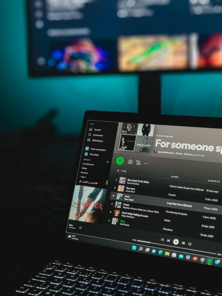 "Laptop playing a curated music playlist in a dimly lit room, inspired by slow living and nostalgic summer nights."