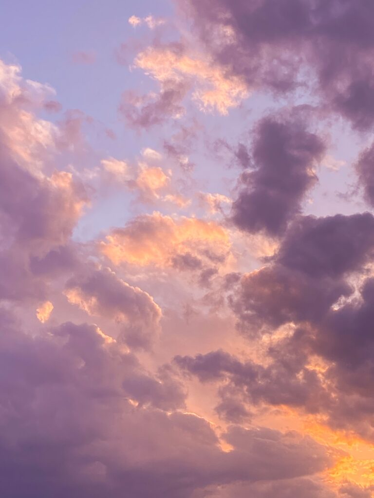 Lavender, peach, and blue sunset clouds scattered across the evening sky, creating a calm and nostalgic cloudscape.