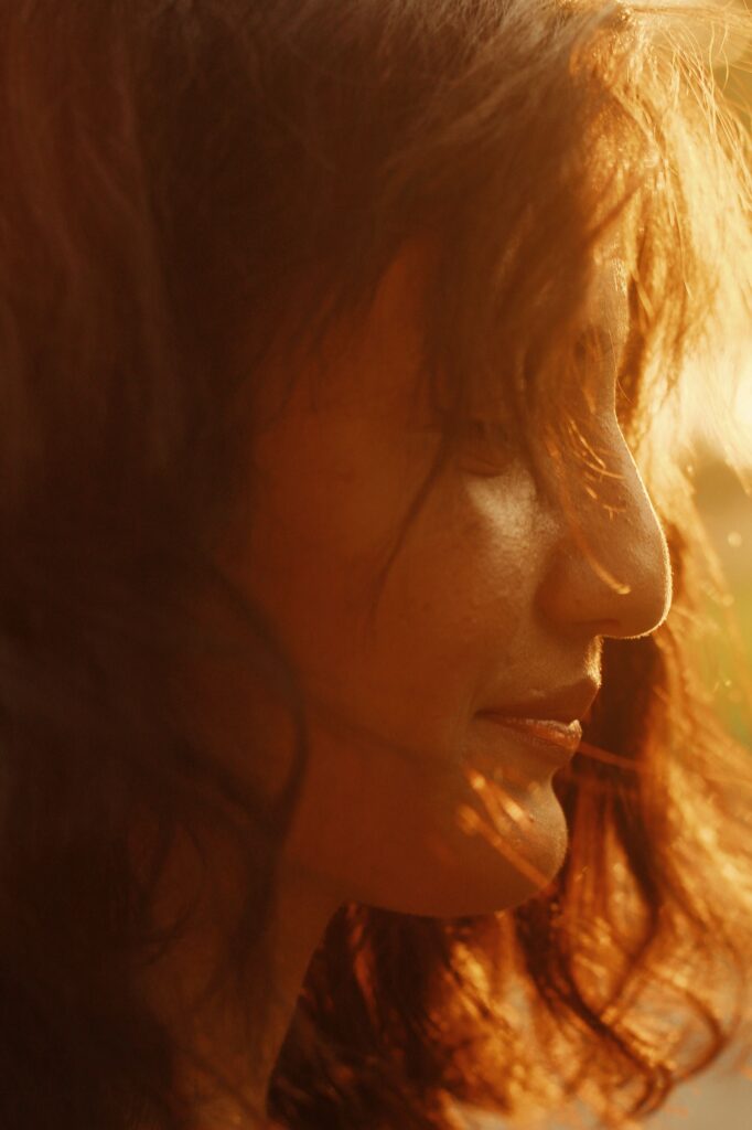 Woman enjoying golden hour sunlight in nature while practicing mindfulness and connecting with nature outdoors