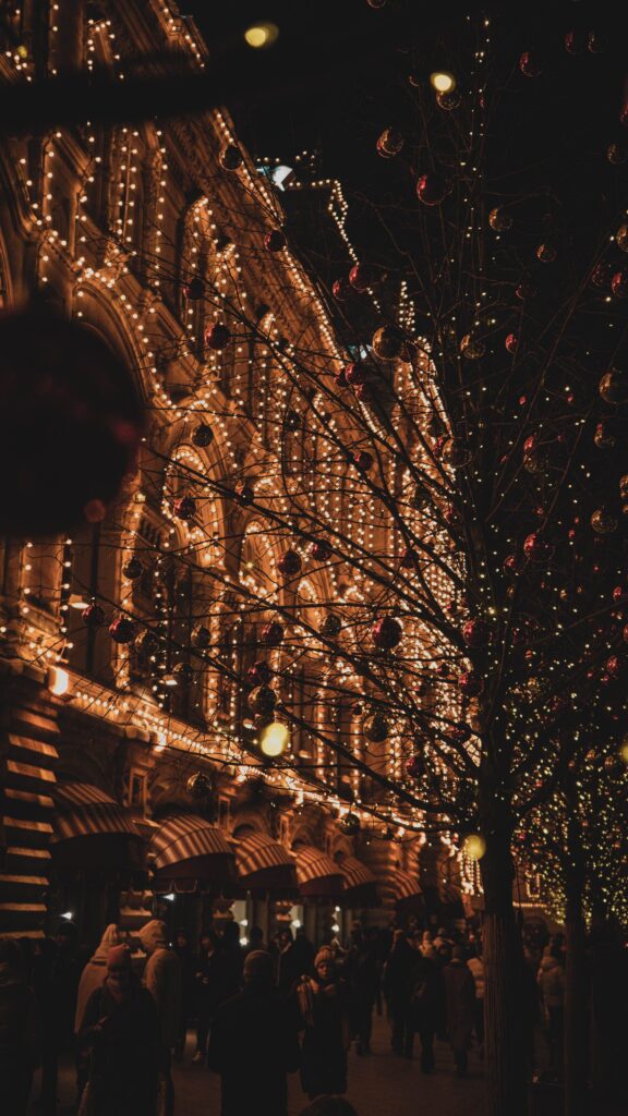 Magical Christmas lights glowing across buildings and trees at night creating a warm cozy Christmas holiday atmosphere