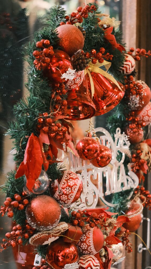 Traditional Christmas greenery decorated with red ornaments bells ribbons and festive holiday decorations